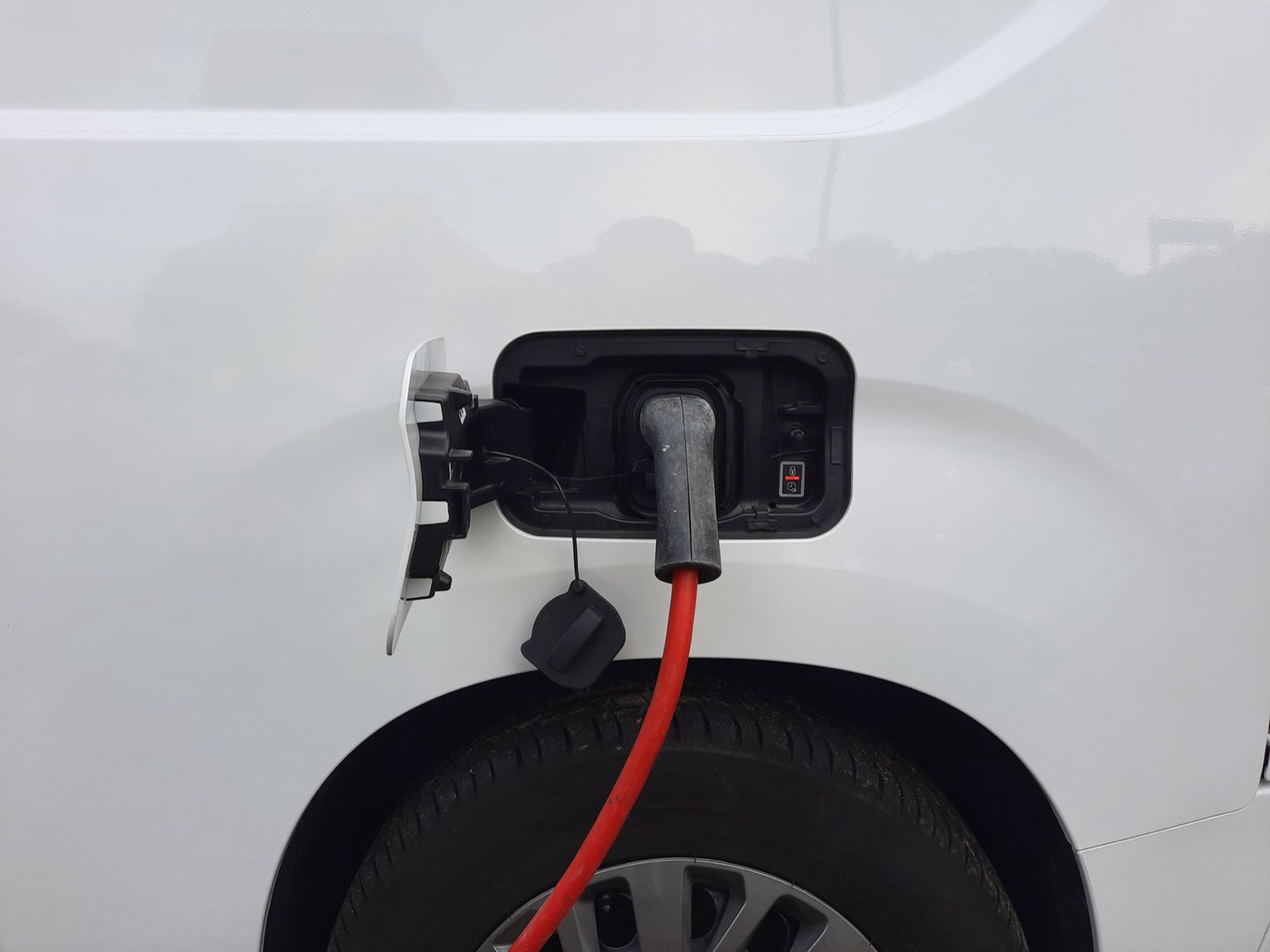 Câble de recharge branché sur la trappe d'une voiture électrique