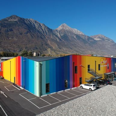 Moderner Freizeitkomplex mit unverwechselbarer Fassade aus KS AT Architekturwandpaneelen in 17 Farben und KS RW Dachpaneelen in Grau – ein echter Blickfang im Industriegebiet von Martigny.