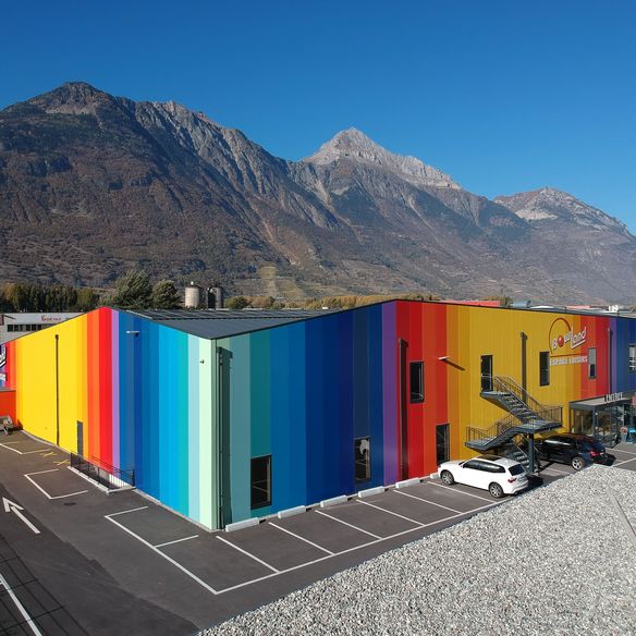 Moderner Freizeitkomplex mit unverwechselbarer Fassade aus KS AT Architekturwandpaneelen in 17 Farben und KS RW Dachpaneelen in Grau – ein echter Blickfang im Industriegebiet von Martigny.