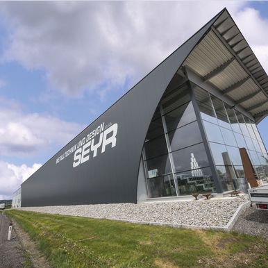 Výrobní hala Seyr Metalltechnik měla vyjadřovat vášeň pro precizní výrobu. Využili jsme systém KS AT fasádní stěnové panely a systém pro opláštění plochých střech KS X-Dek™ XD střešní panely.