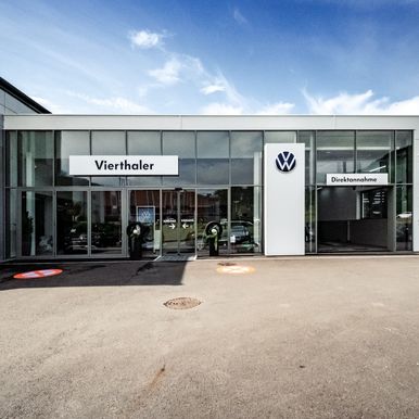 Neubau und Erweiterung auf 5.500 m² mit KS AT Architekturpaneelen im Flat-Profil Reinweiß und Micro-Profil Anthrazitgrau präzise auf die Marken-CI abgestimmt.