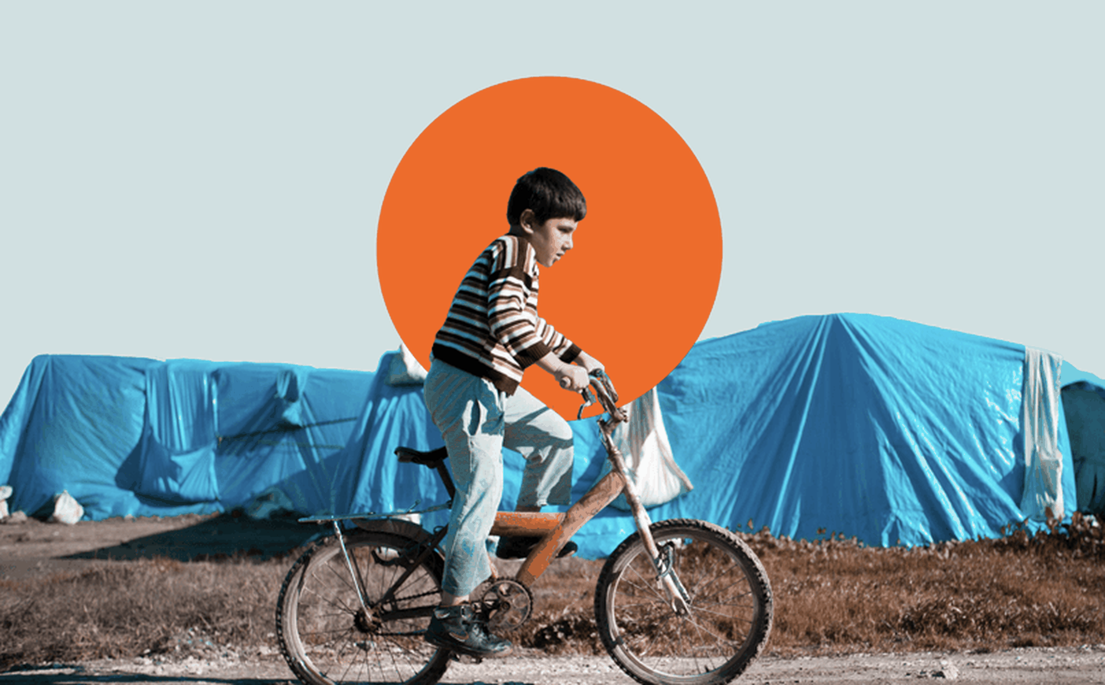 A young boy rides a bicycle in front of a row of makeshift tents covered with blue tarps. The sky is clear, and a large orange circle is superimposed in the background.