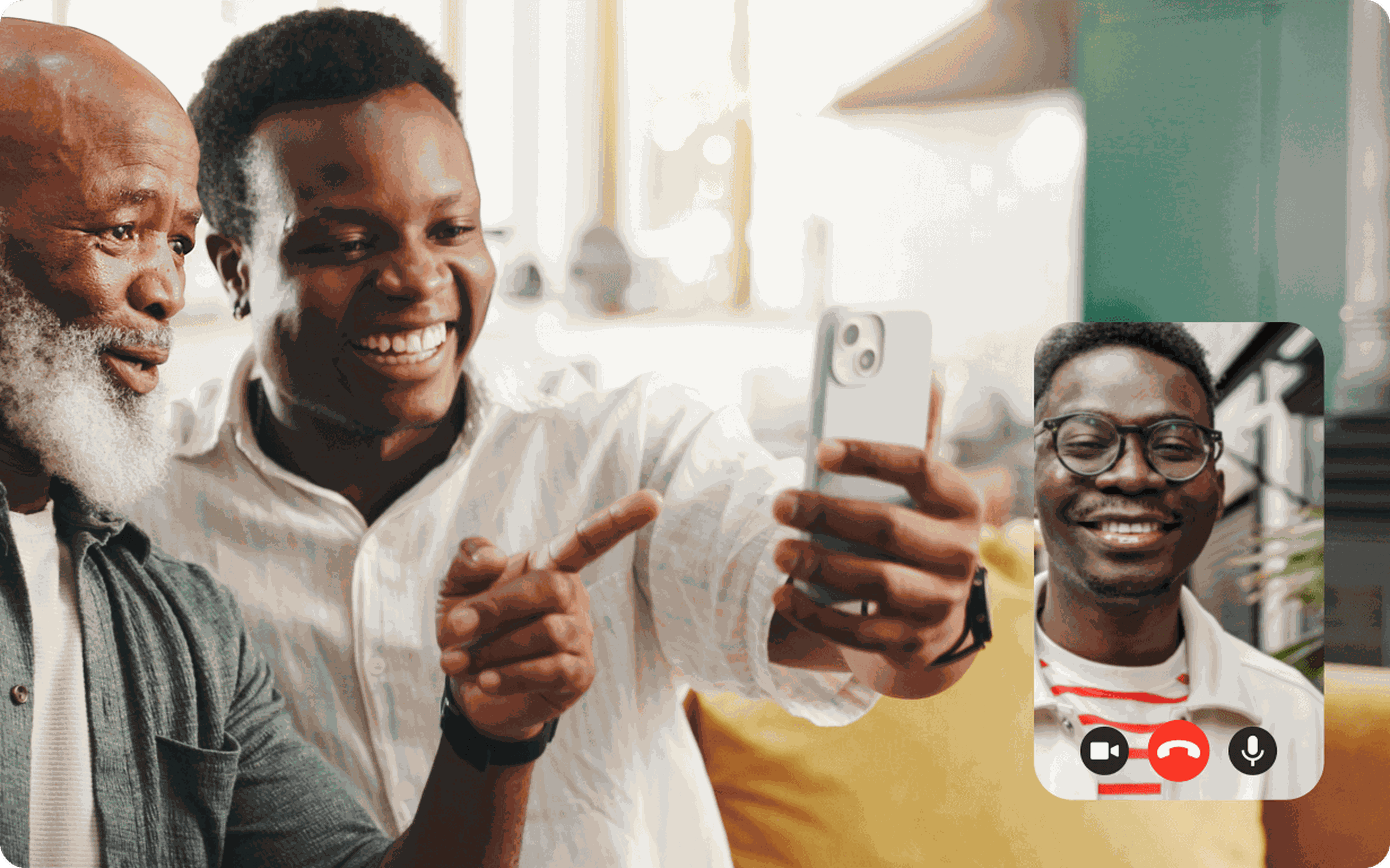 Two smiling men sit together on a couch, taking a selfie during a video call with a third smiling man shown in a small on-screen window, perhaps discussing Ethiopia remittances. The atmosphere is bright and cheerful.