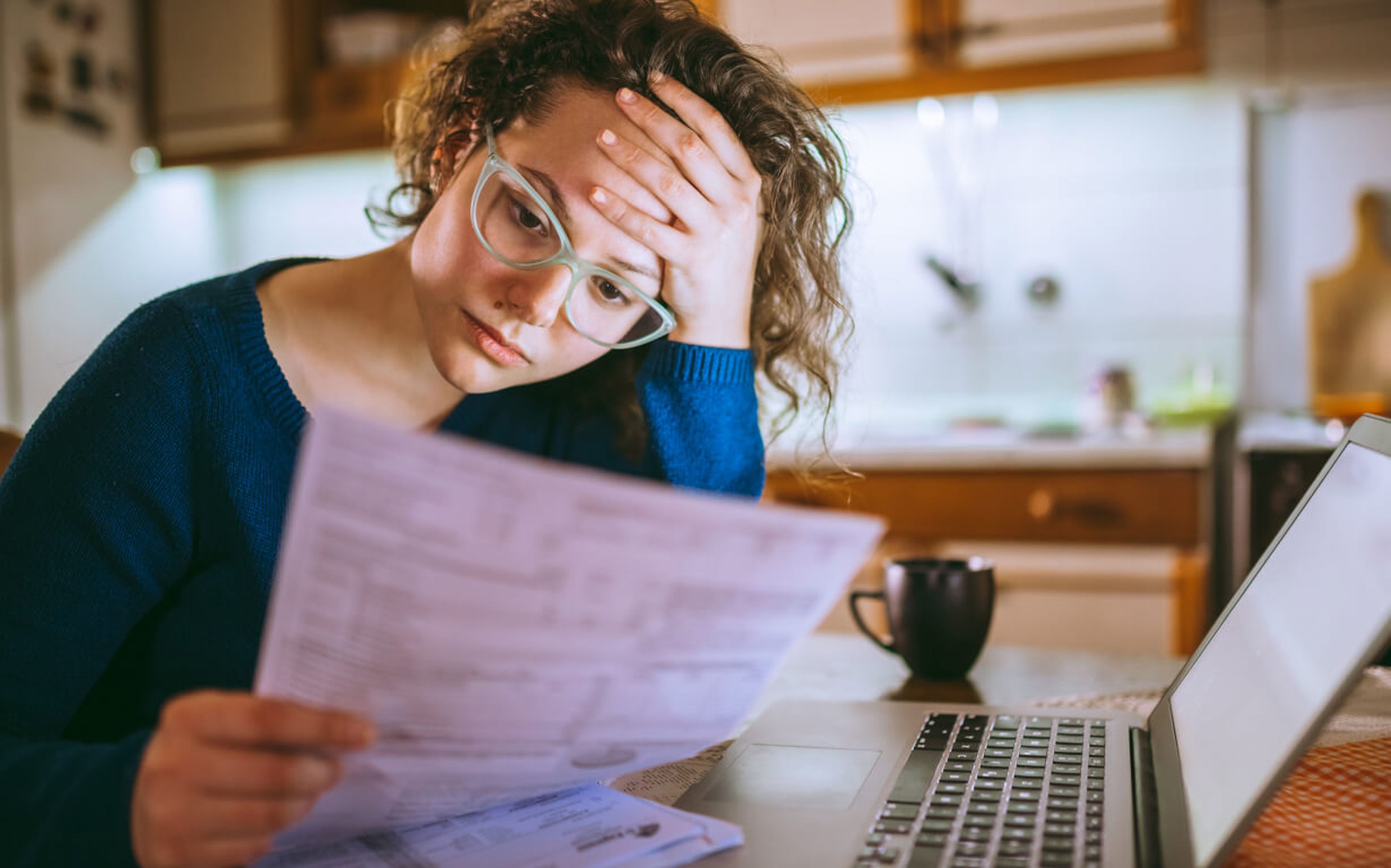 Woman overwhelmed at financial documents.