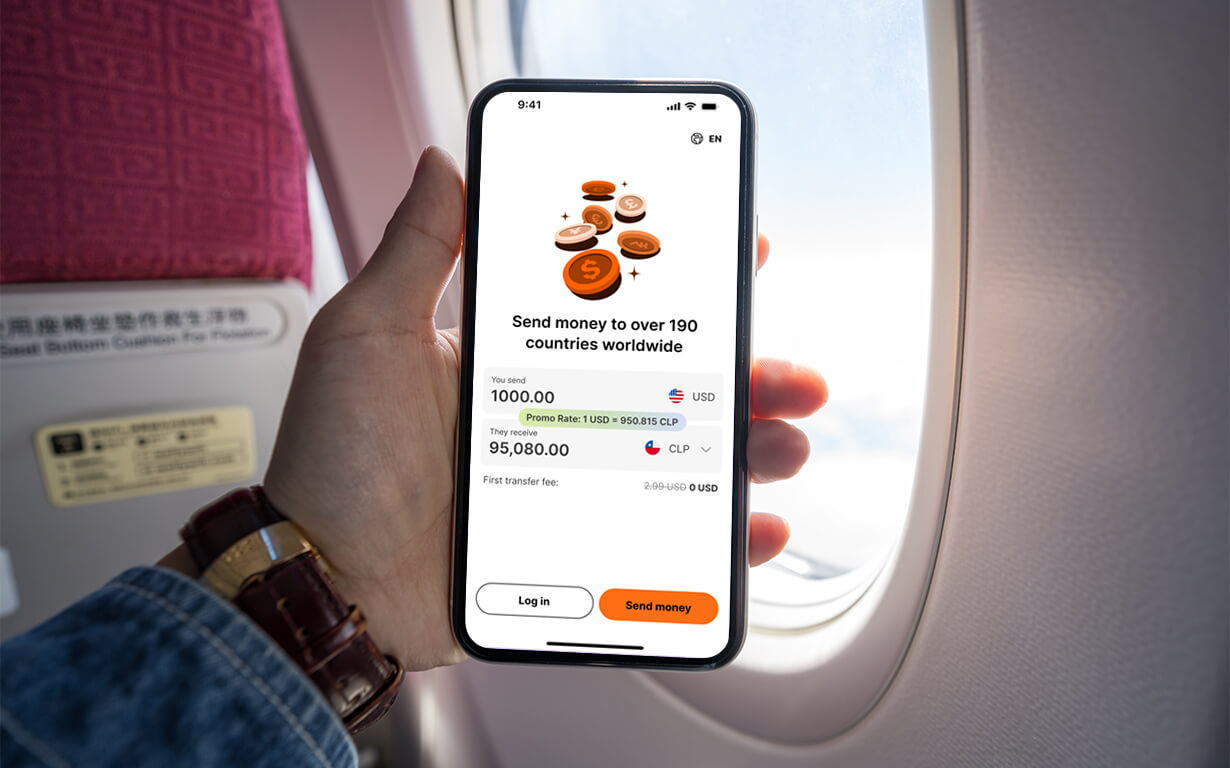 A person holds a smartphone displaying the Ria app, showing options to send funds in USD to CLP, in front of an airplane window. Sunlight pours through the window, illuminating a partially visible red seat.