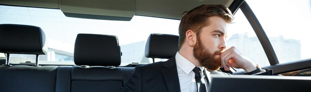Außendienstmitarbeiter nimmt während seiner Autofahrt an Audio-Seminaren teil