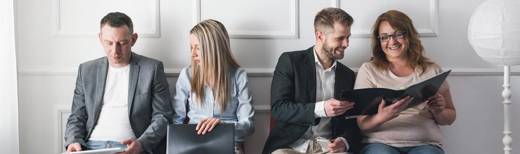 Vier Mitarbeiter teilen sich einen Arbeitsplatz und verteilen selbständig die Aufgaben untereinander. 