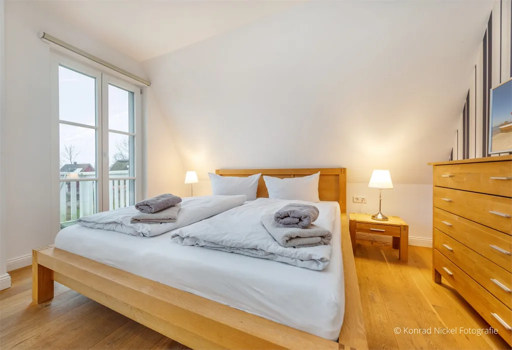 Ruhiges Schlafzimmer mit weißer Bettwäsche und grüner Akzentwand