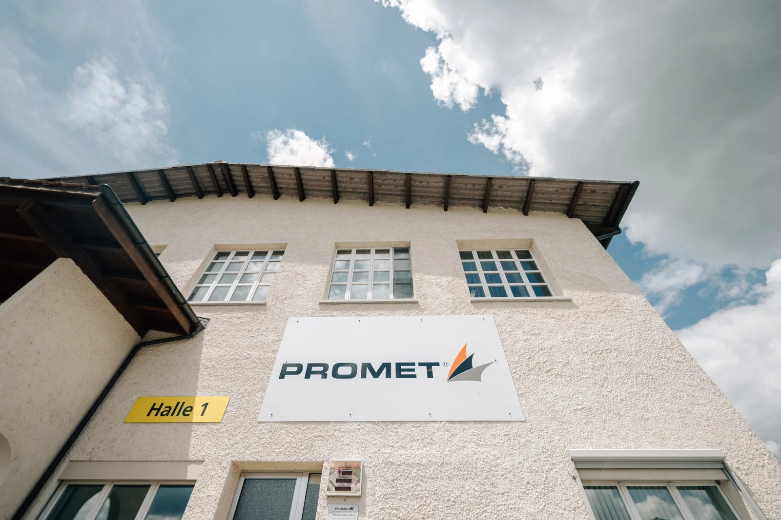 Firmenschild der Promet AG an der Fassade von Halle 1