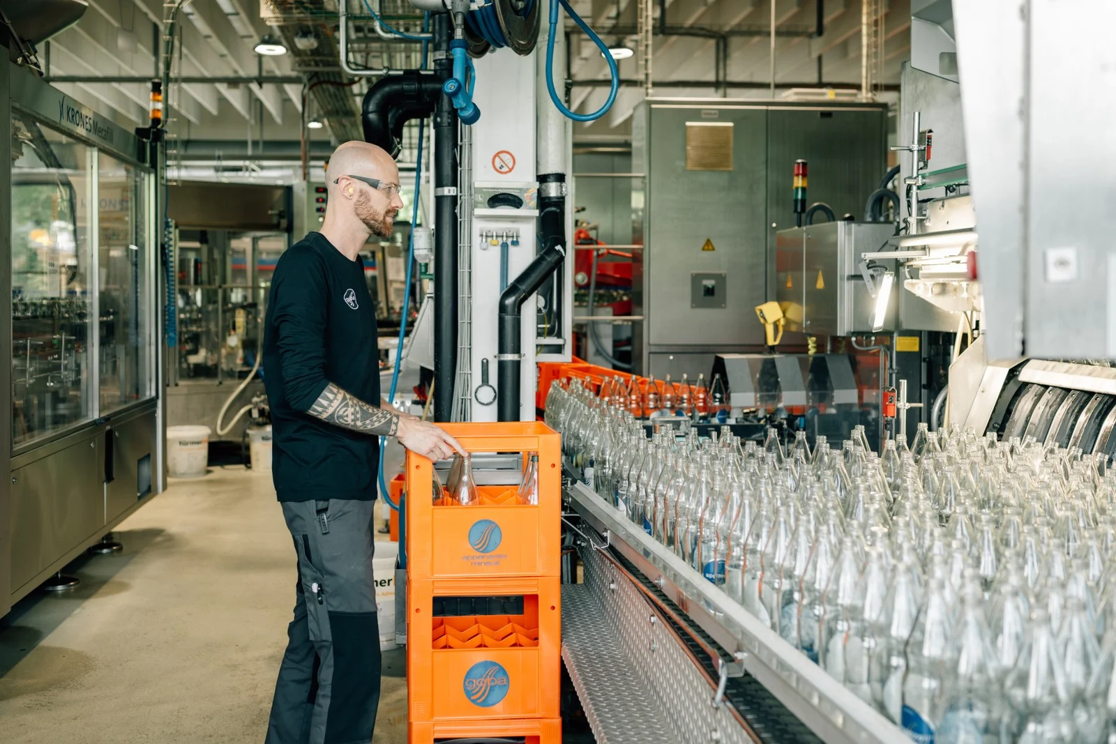 Mitarbeiter an der Abfuellanlage mit Glasflaschen bei der Goba AG