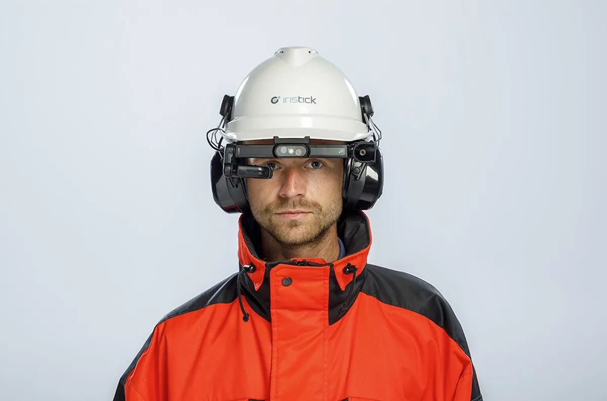 Field service worker wearing Iristick.H1 smart glasses on a safety helmet