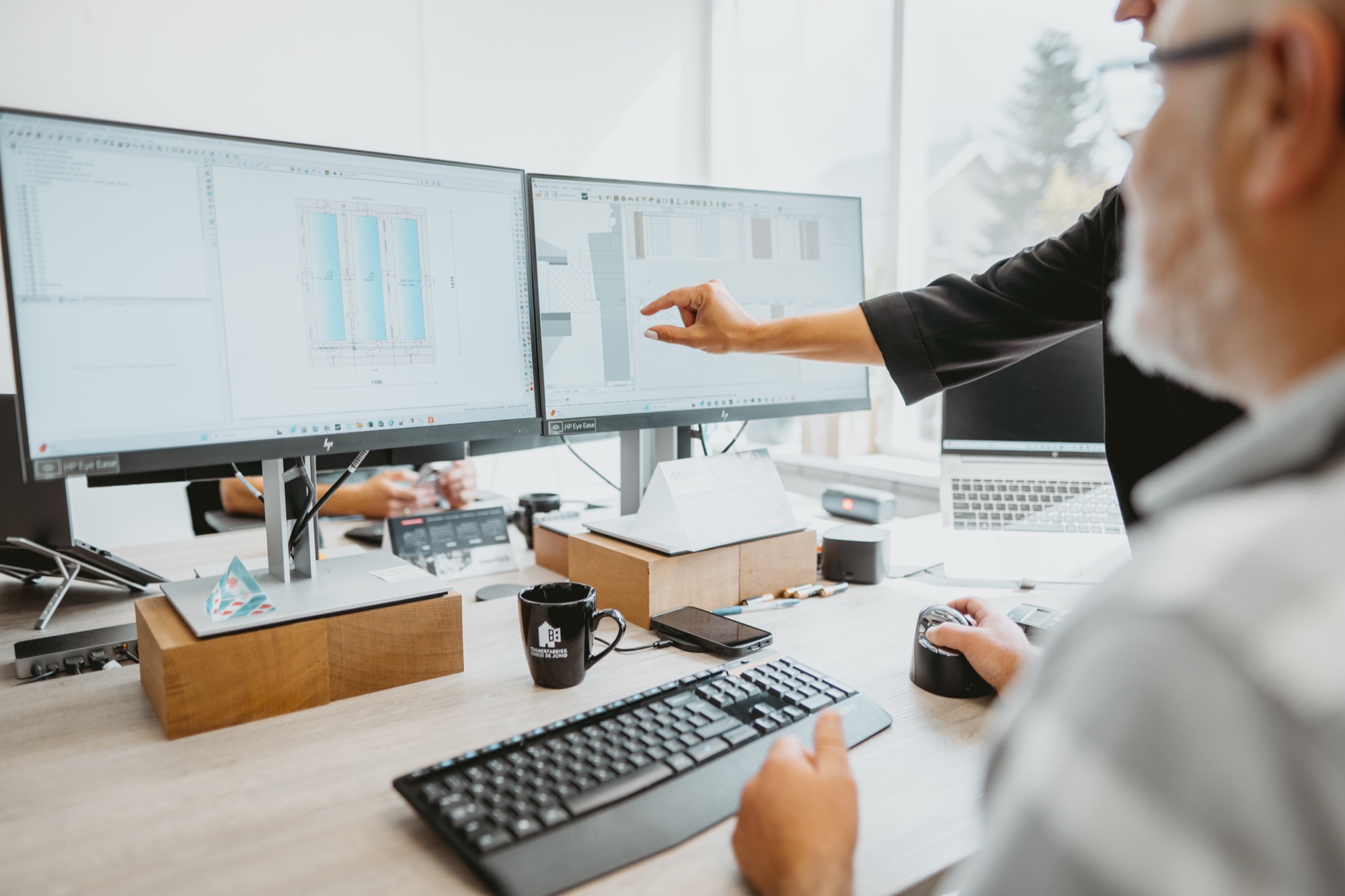 Werkvoorbereider wijst details aan op een CAD-tekening