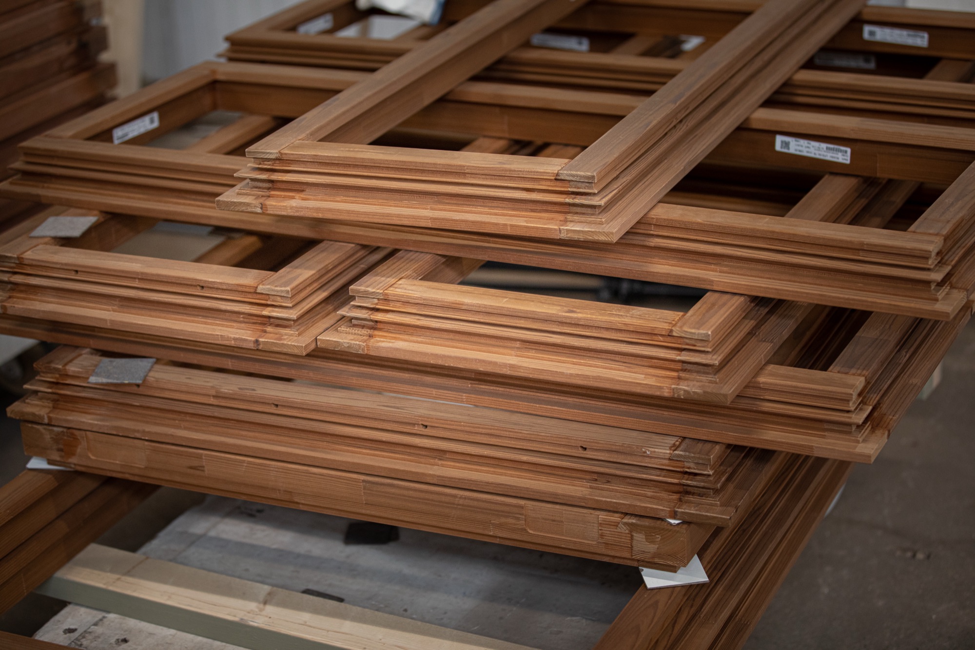 Stapel gereed houten kozijnen in de werkplaats van Timmerfabriek De Jong