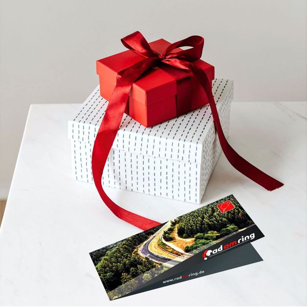 Gutschein für Rad am Ring auf einem Tisch mit einem Geschenk
