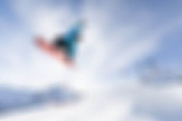 Ein Snowboarder beim Sprung über einen Kicker.