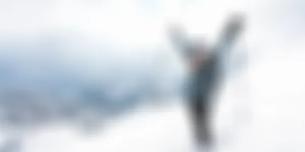 Eine glückliche Frau im Schnee mit hochgerissenen Armen