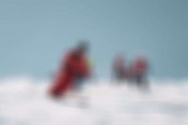 Ski instructor skiing in front of a group of kids