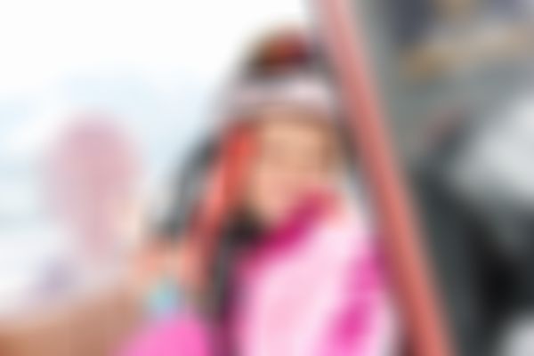 Girl in skiing outfit inside gondola