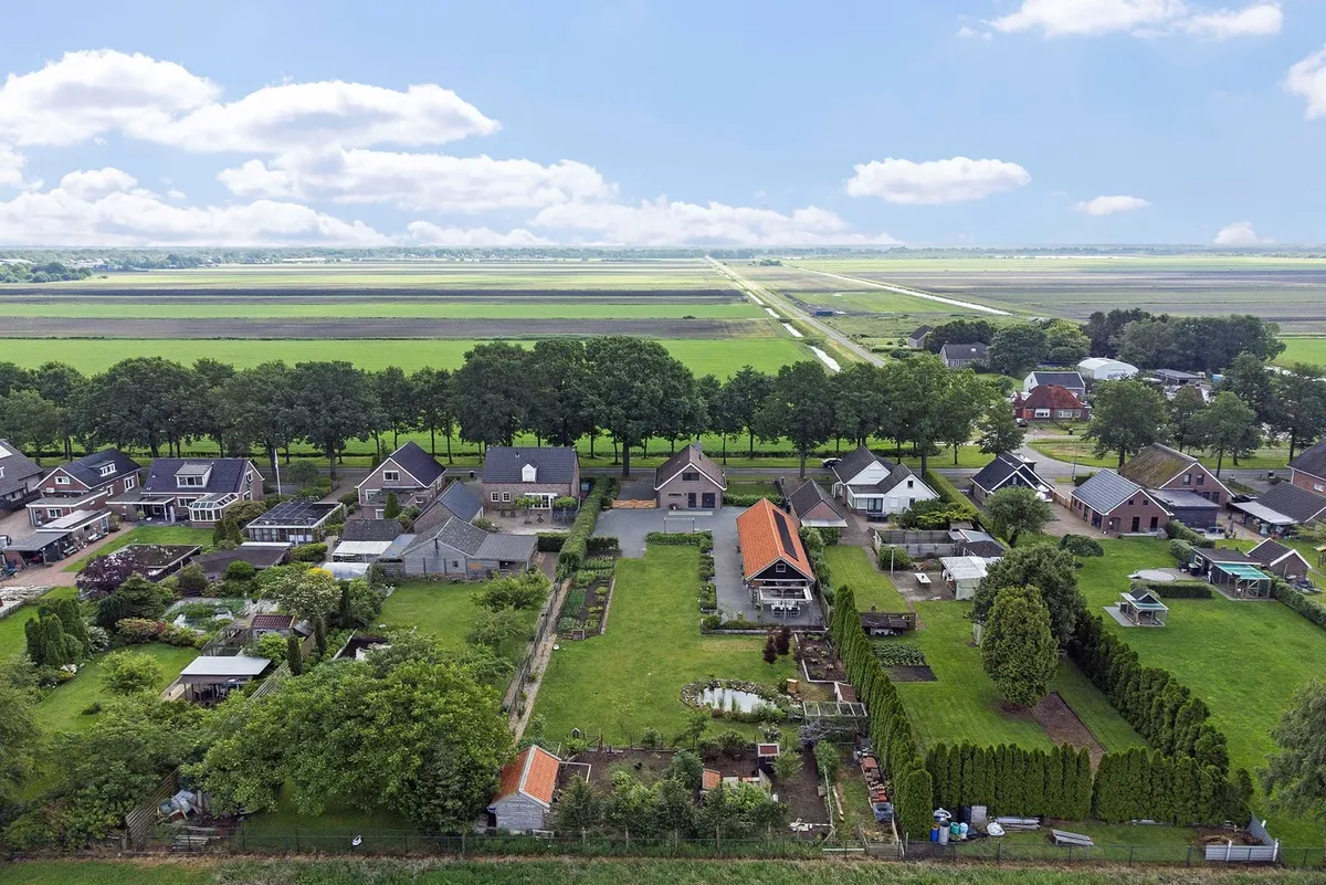 Luchtfoto van een dorp met weilanden tot aan de horizon
