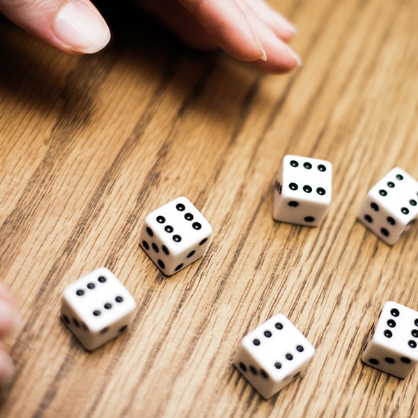 hand gooit vijf dobbelstenen op tafel