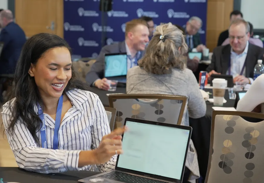 A woman pitching from a laptop at an MTI pitch event