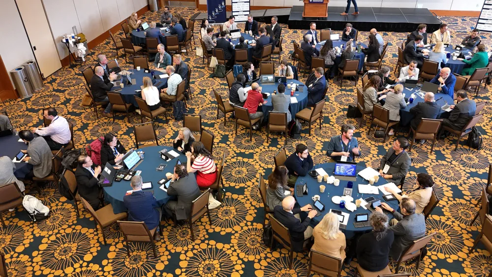 Founders and judges at round tables during a 2025 MTI pitch event