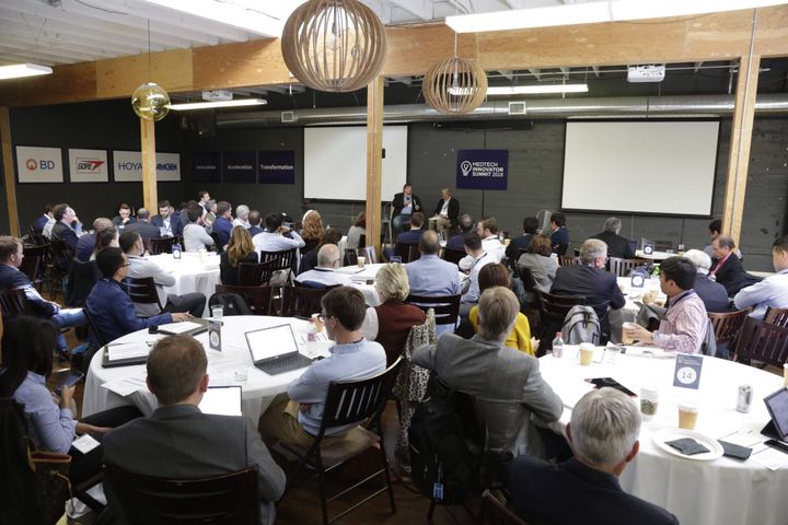 Audience at round tables watching a fireside chat at MedTech Innovator Summit 2018