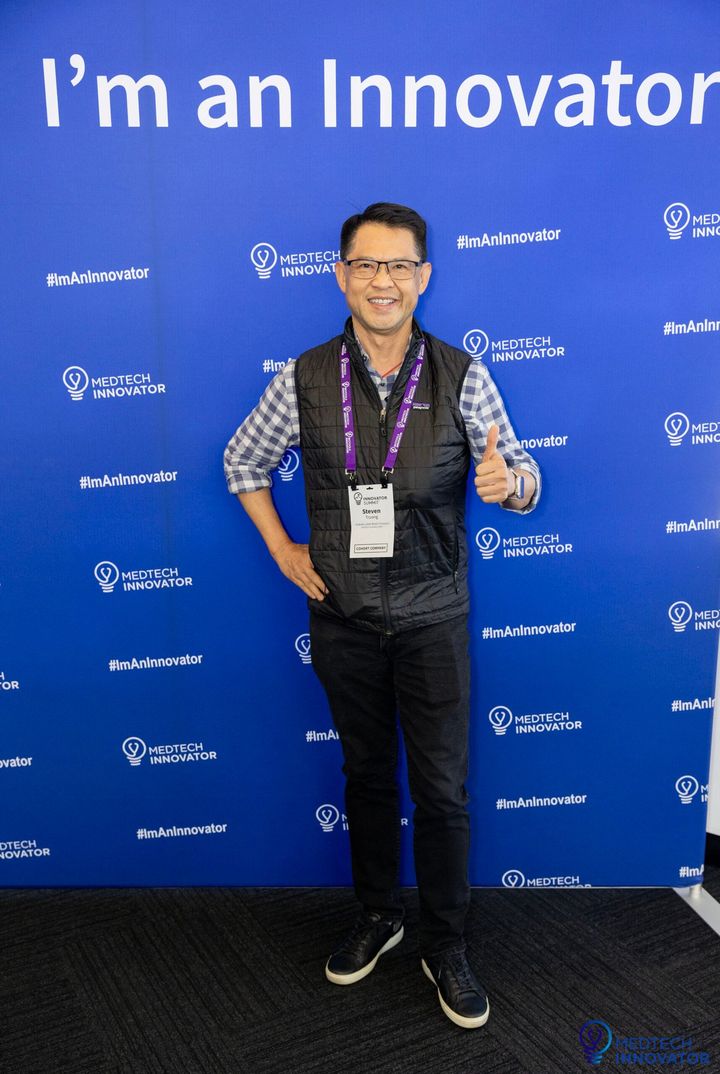 Attendee giving a thumbs up in front of the "I'm an Innovator" wall at Innovator Summit 2024