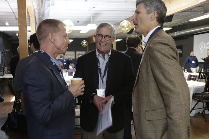 Three attendees talking at the MedTech Innovator Summit 2018