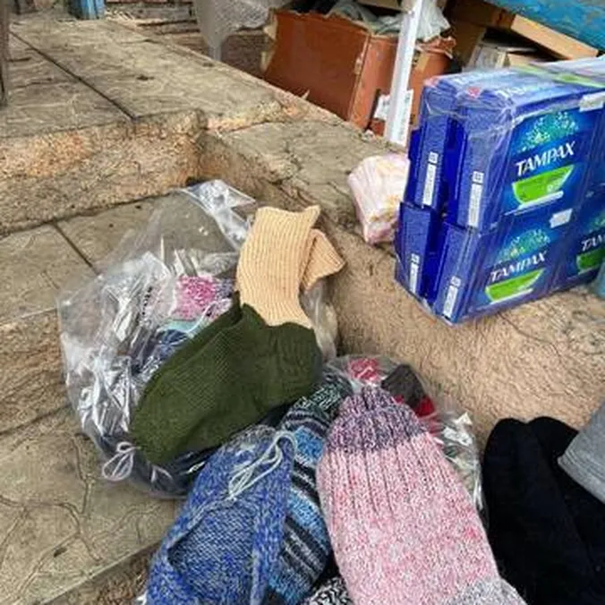 Poser med strikkede uldsokker og hygiejneartikler står klar på en stentrappe