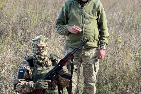 To ukrainske soldater i camouflage på en mark med poser fyldt med konserves leveret som nødhjælp fra Danmark
