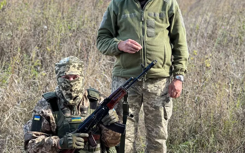 To ukrainske soldater i camouflage på en mark med poser fyldt med konserves leveret som nødhjælp fra Danmark