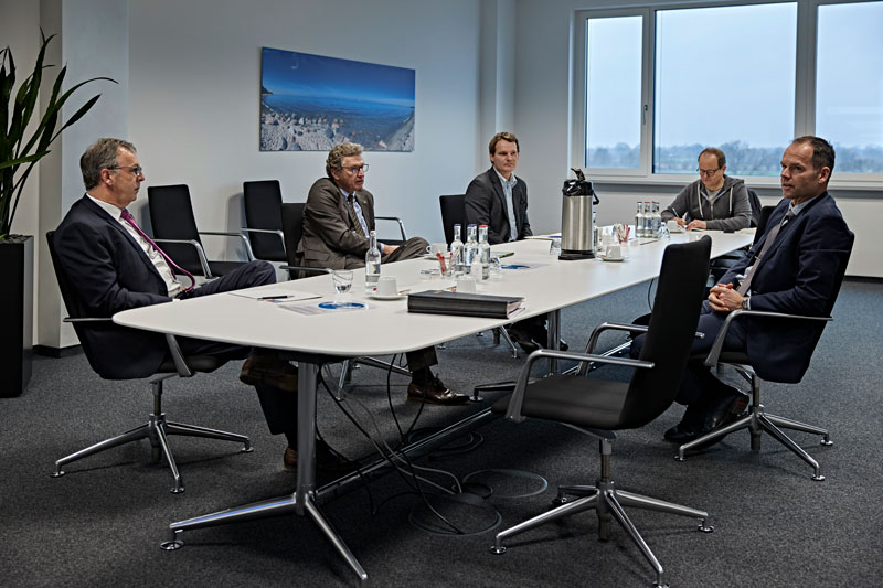 Fünf Männer an einem Konferenztisch im Besprechungsraum