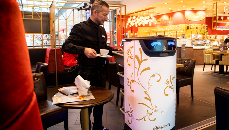 Serviceroboter bringt Getränke an einen Café-Tisch