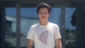Junger Mann im weißen T-Shirt vor Glasfassade