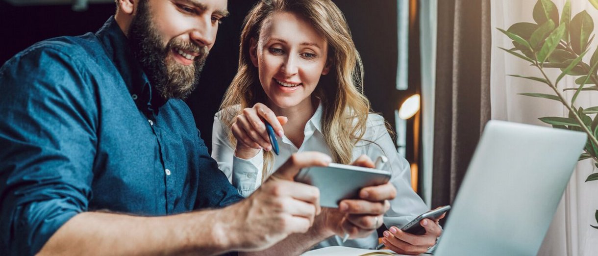 Mann und Frau blicken gemeinsam auf ein Smartphone