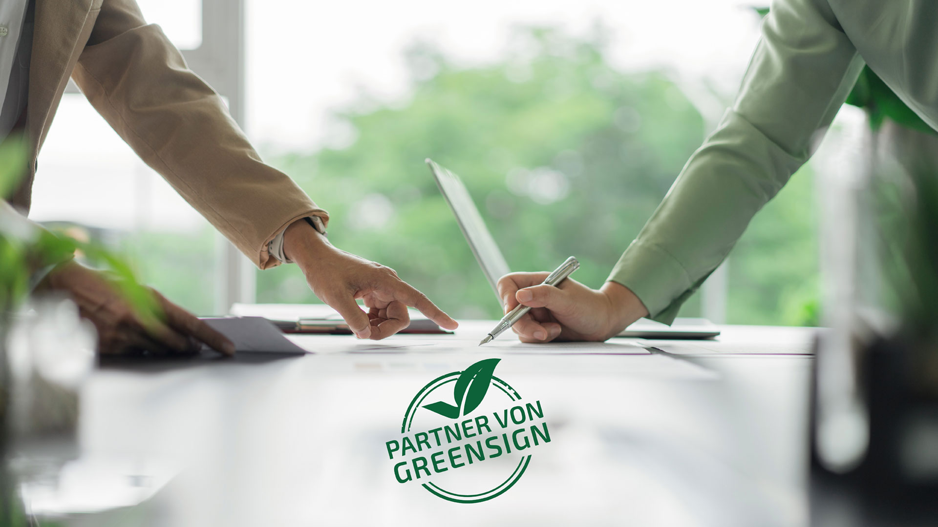 Zwei Personen unterschreiben Dokumente, Siegel Partner von GreenSign