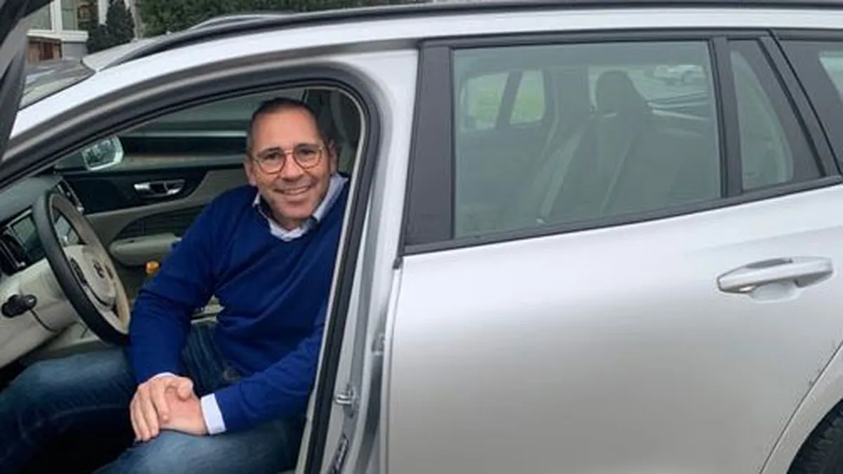 Mann im blauen Pullover sitzt in einem Auto