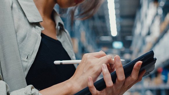 Frau mit Tablet und Eingabestift im Lagergang