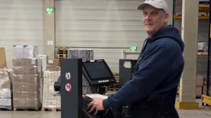 Mitarbeiter bedient einen Elektro-Hubwagen im Lager