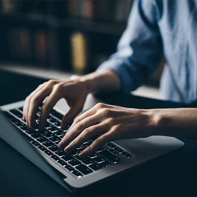 Bildausschnitt mit Hände auf Computertastatur
