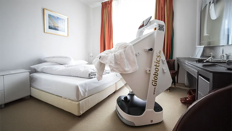 Serviceroboter legt frische Wäsche in einem Hotelzimmer ab