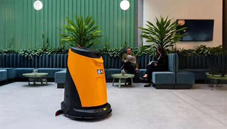 Oranger Scheuersaugroboter in einer Lounge