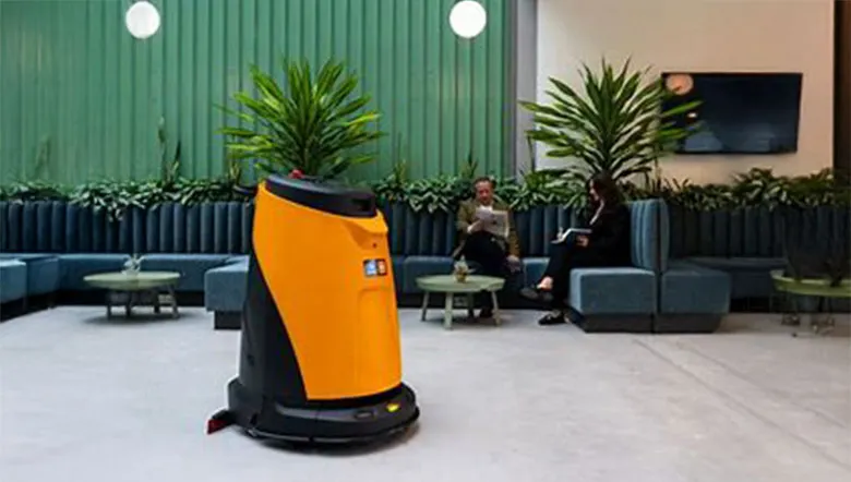 Oranger Scheuersaugroboter in einer Lounge