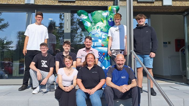 Gruppenfoto von Auszubildenden vor dem Firmengebäude