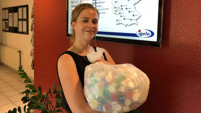 Frau hält einen Sack voller Plastikdeckel