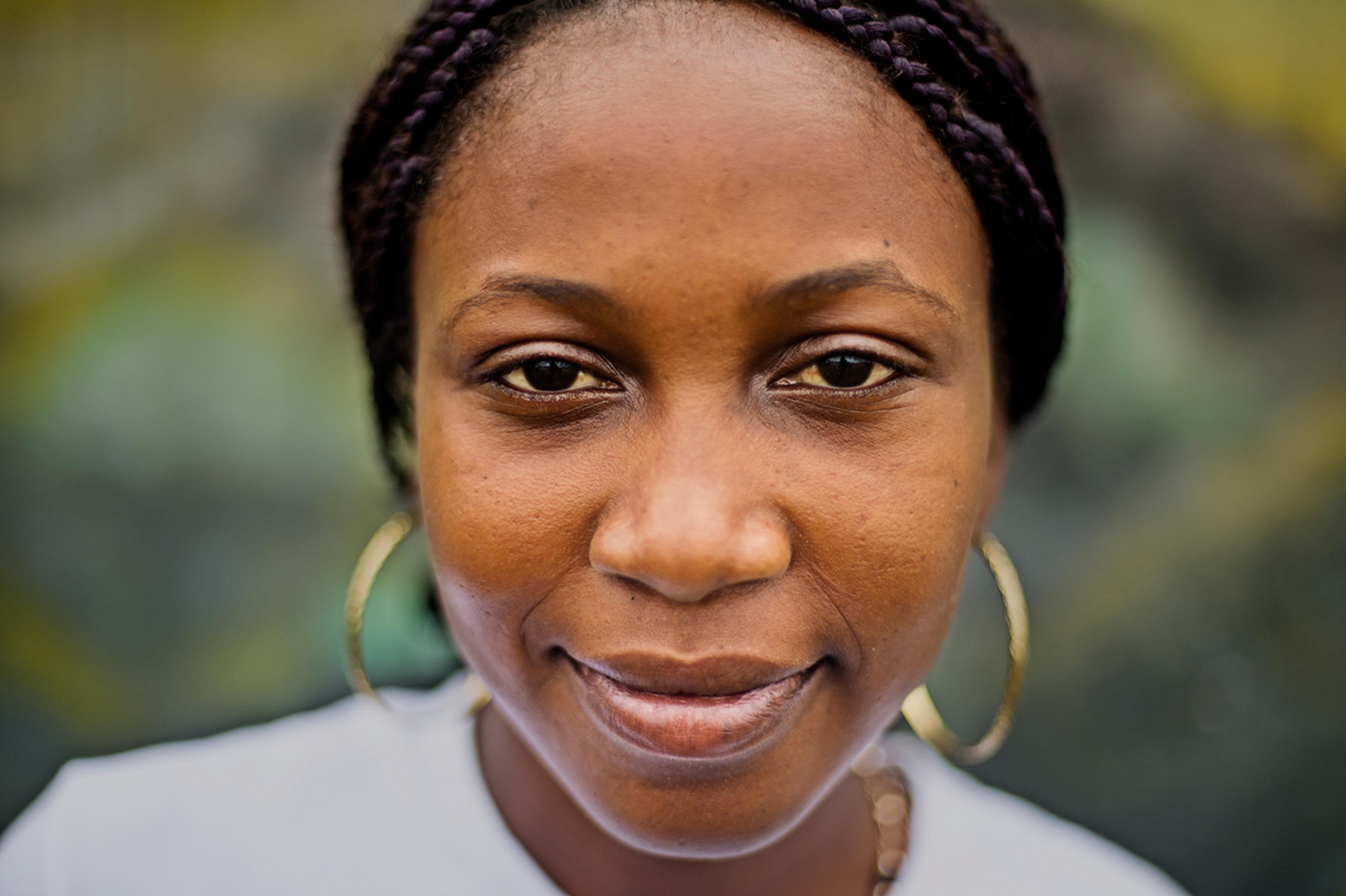 women with dark skin and golden earrings looking into the camera