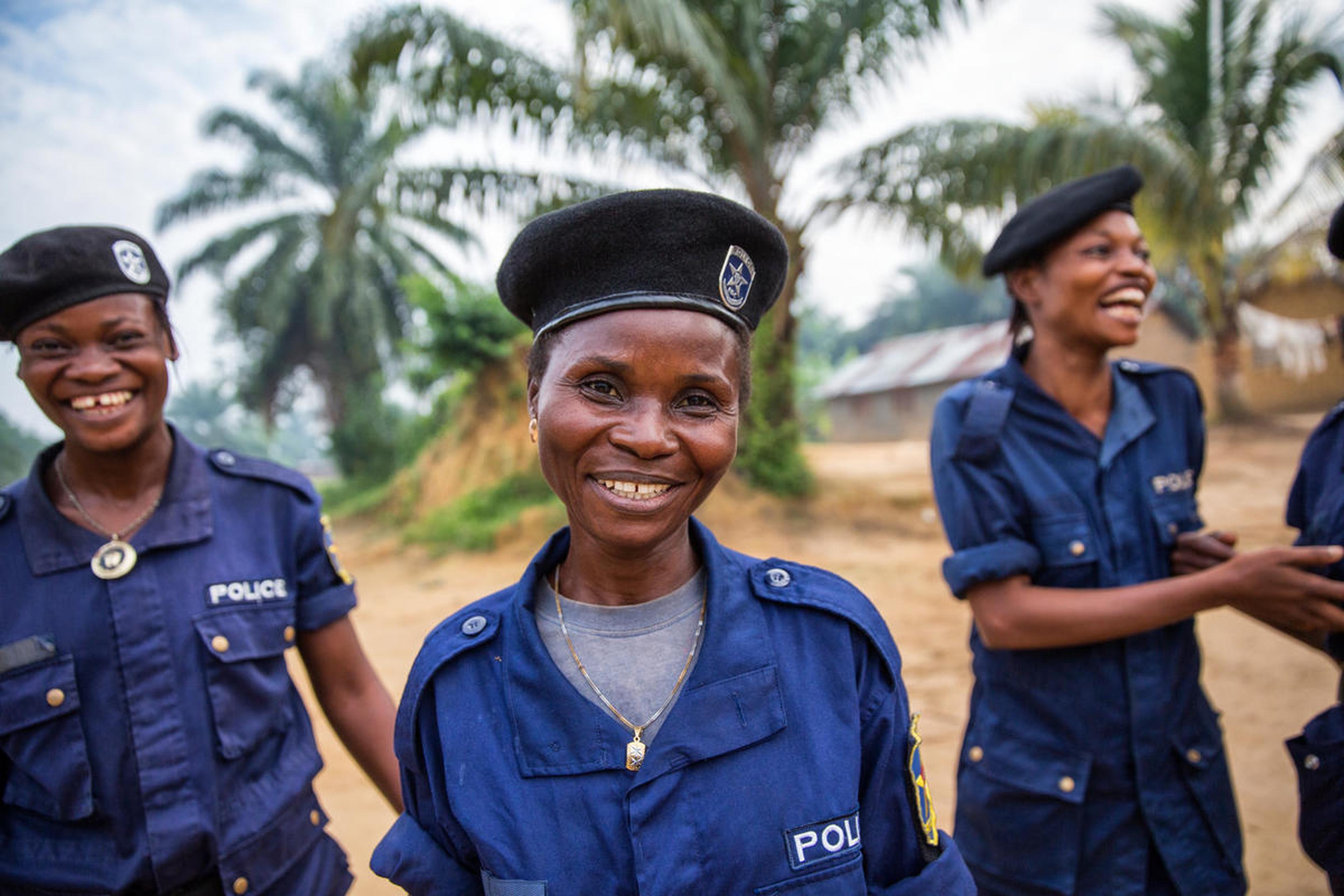 drie vrouwen met blauw politie uniform aan en baret op