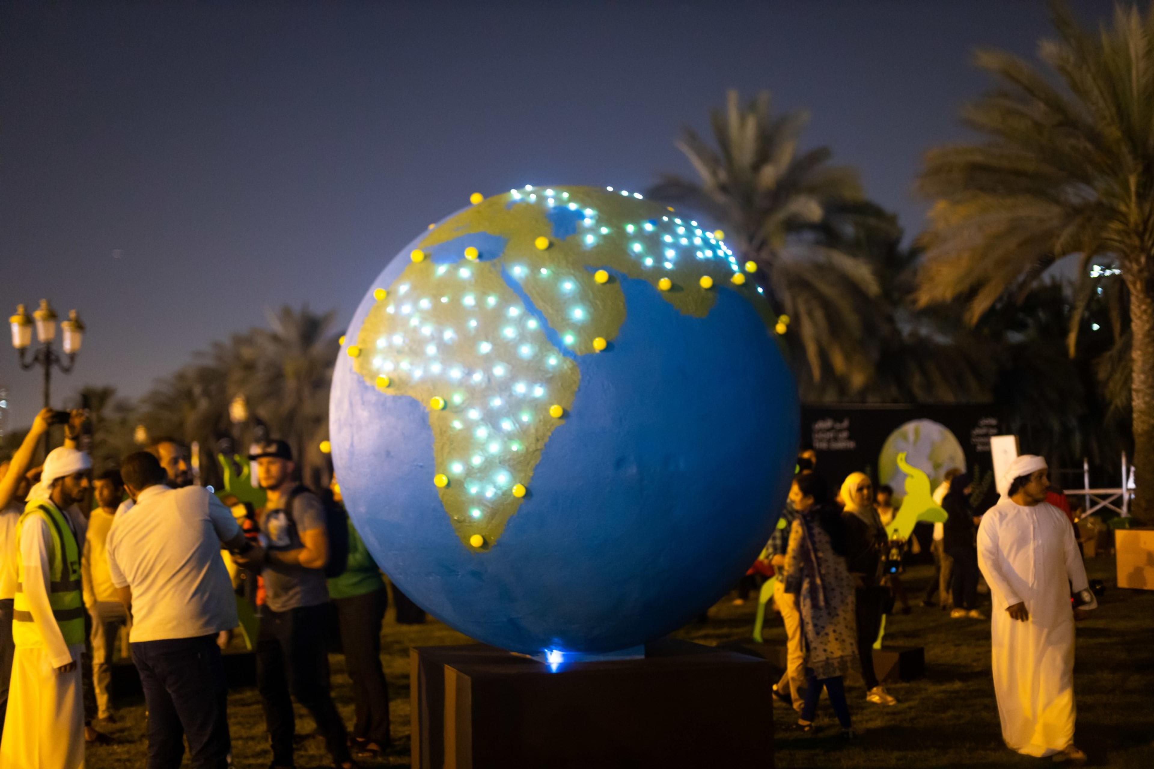 Grote aardbol met lichtjes erop op evenement