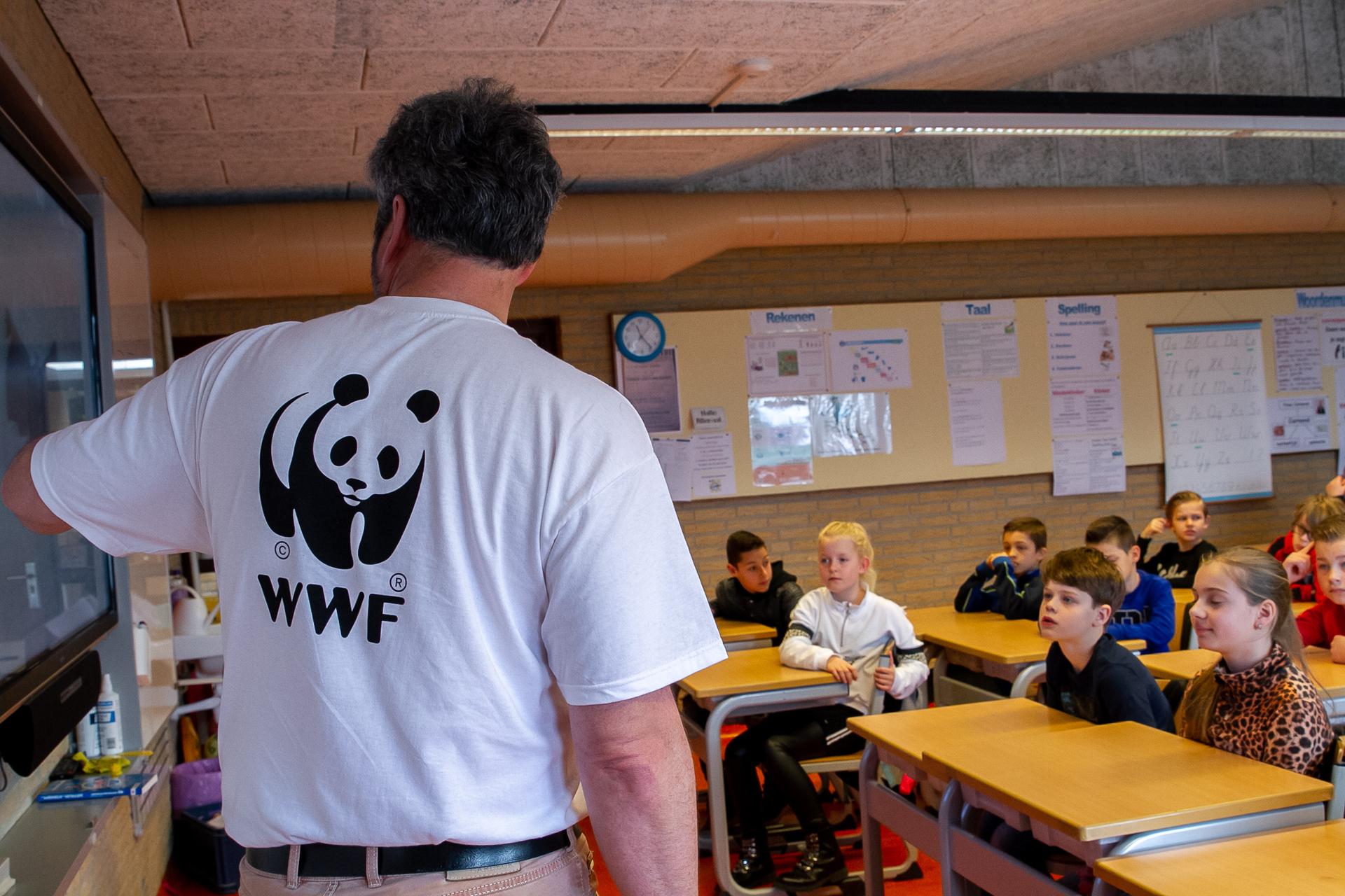 Man met WWF t-shirt staat voor klas met kinderen